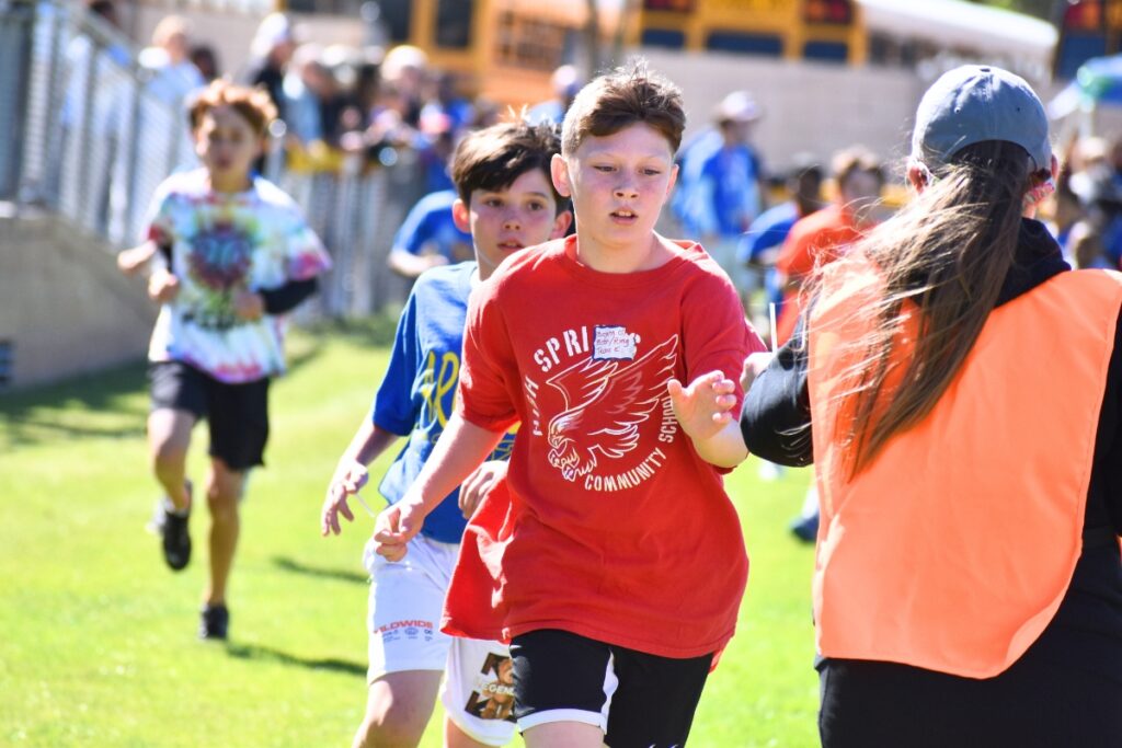 A High Springs Community Schools student takes a straw to help count the laps during the boys' one-mile race. Photo by Glory Reitz