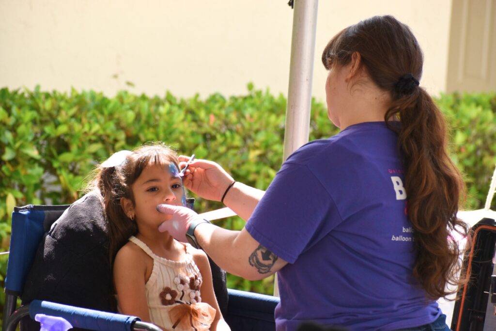 A girl receives a face paint job. Cred Glory (1)