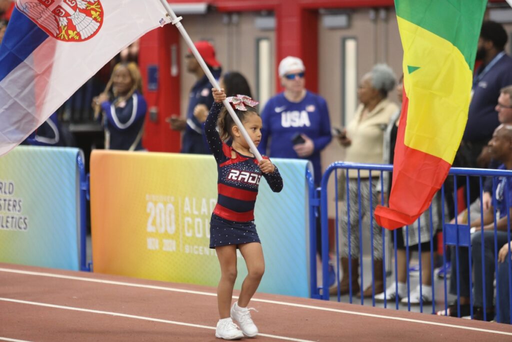 A member of RADD Sports cheer team carries a flag during the Parade of Nations. 