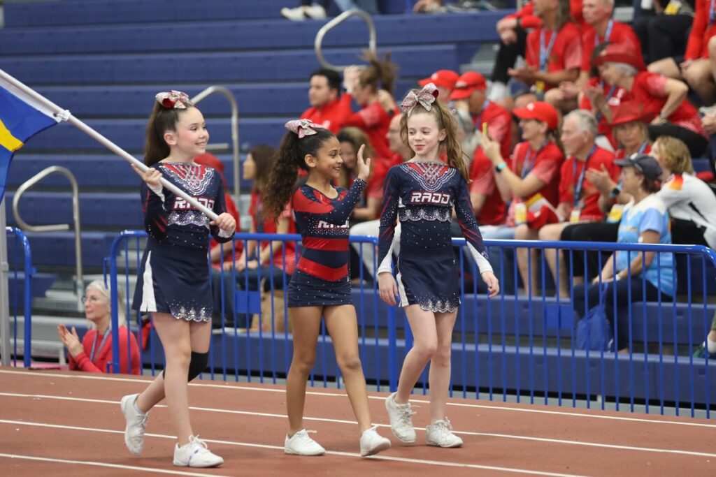 Cheerleaders with RADD Sports carry country flags without participants in the Parade of Nations. 