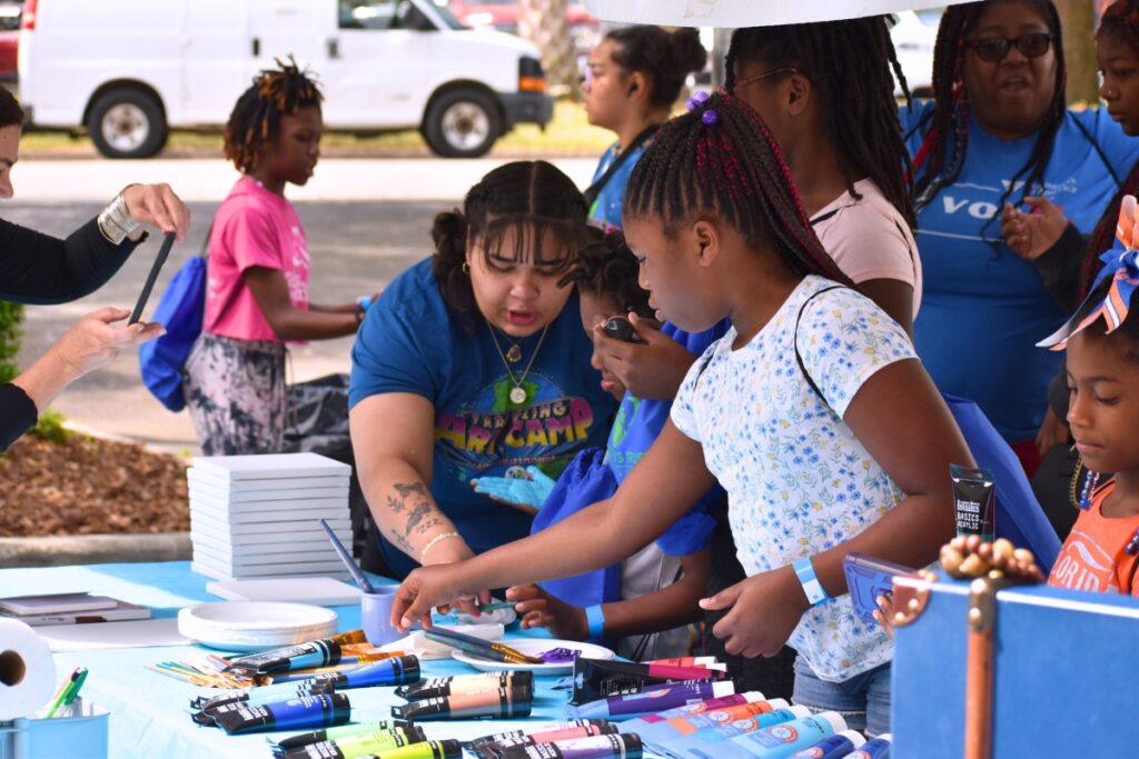 Children check out paint supplies at a booth. Photo by Glory Reitz