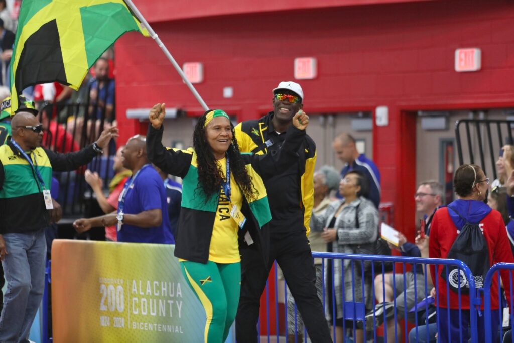 Members of Team Jamaica display their flag while walking around the track. 