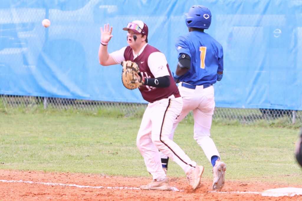 Oak Hall's Cameron Currier juggles the ball as Newberry's Desmond Taylor gets safely to first base. Photo by C.J. Gish