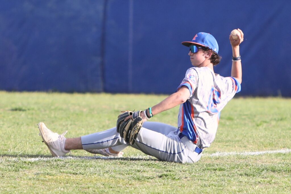 P.K. Yonge's Jude Gratto throws the ball in after a diving catch for an out against St. Francis Catholic. Photo by C.J. Gish