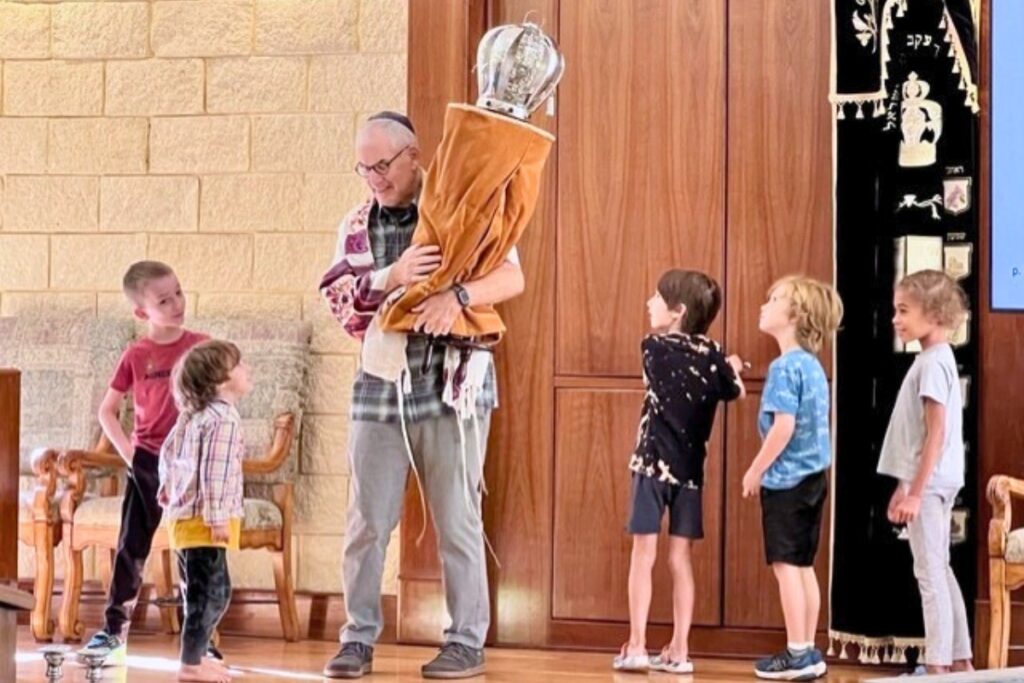 Rabbi Michael Joseph picks up the Torah and carries it around as part of a service. Courtesy of Shir Shalom