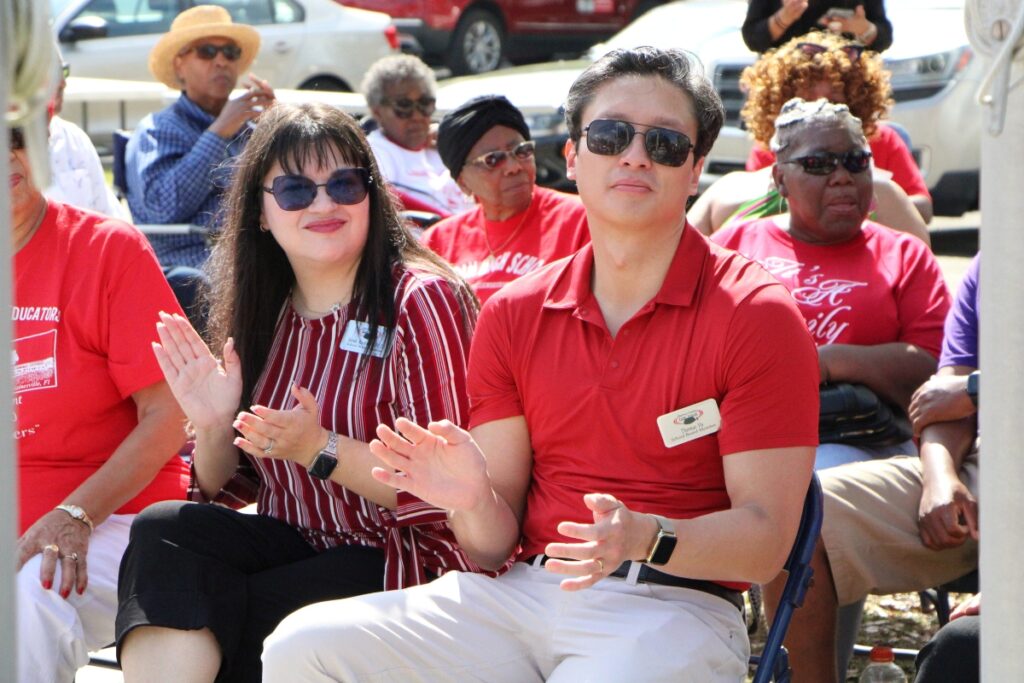 Sarah Rockwell (left) and Thomas Vu represent the Alachua County School Board and clap along to the Eastside High School alumni band at the LHS wall unveiling. Photo by Lillian Hamman