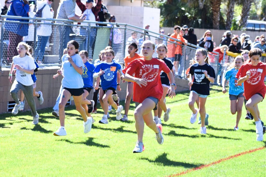 Students take off from the starting line in the girls one-mile race. Photo by Glory Reitz