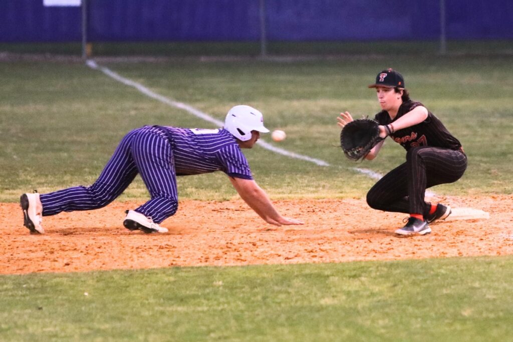 Union County's Jake Walker dives back to first base safely ahead of a throw to Trenton's Pierson Weatherilt. Photo by C.J. Gish