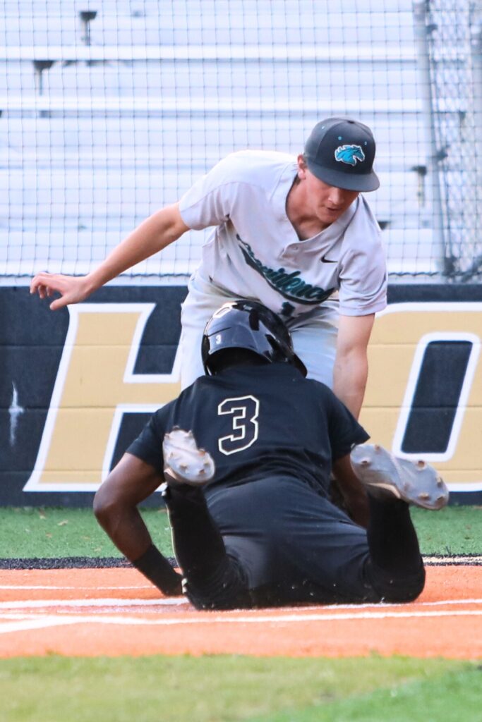 Buchholz's Cedaris Smith slides home safely on a passed ball to put the Bobcats up 8-1 in the bottom of the fourth inning against Providence (Jacksonville). Photo by C.J. Gish