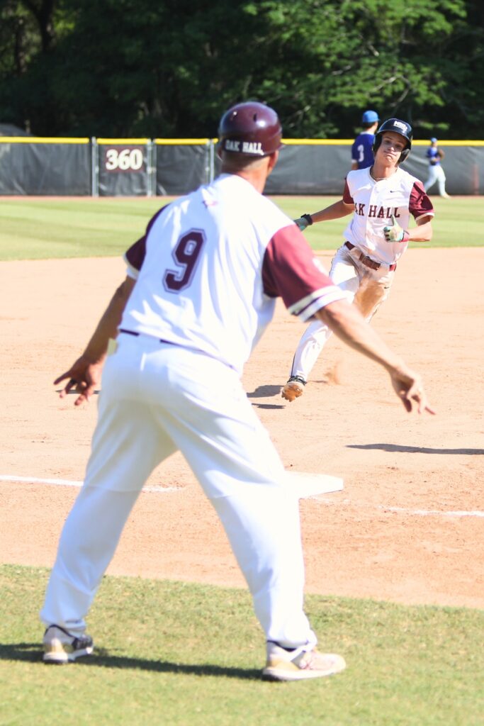 Oak Hall coach Kevin Maris sends Graham Rosenstone home for a run in the fourth inning against St. Francis Catholic in the Class 1A-District 5 championship game. Photo by C.J. Gish