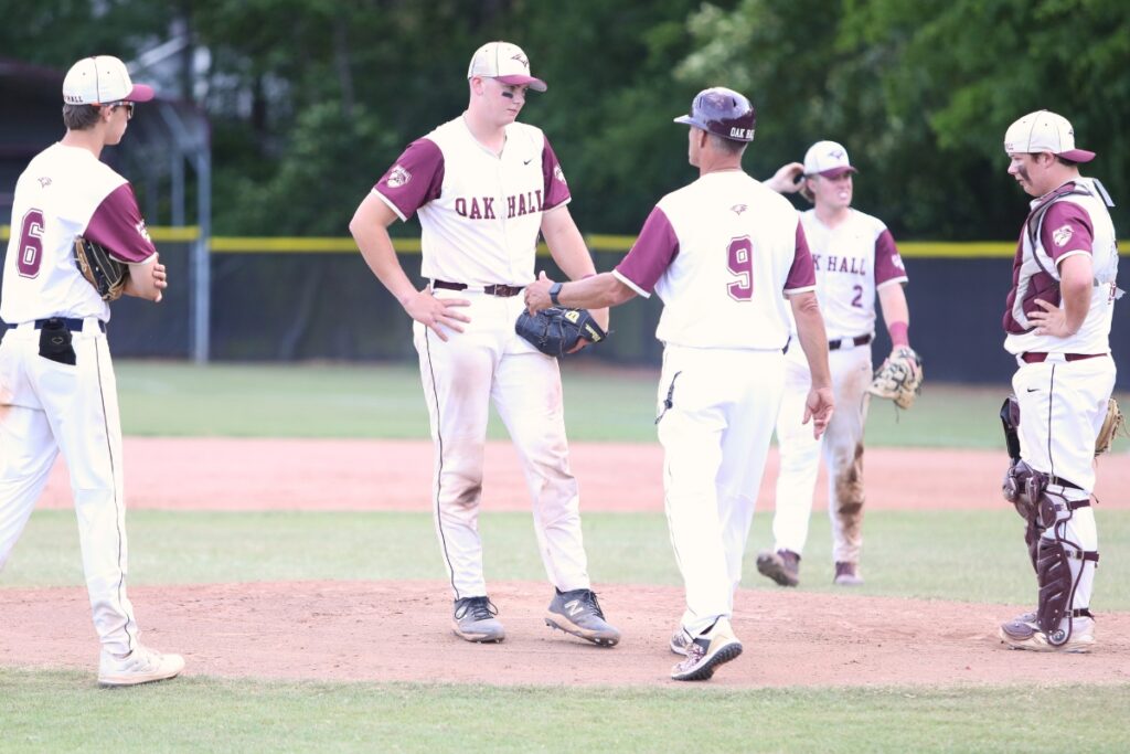 Oak Hall coach Kevin Maris talks with pitcher Brody Beaupre in the seventh inning against St. Francis Catholic in game three of the 2025 1A Region 2 Quarterfinals.