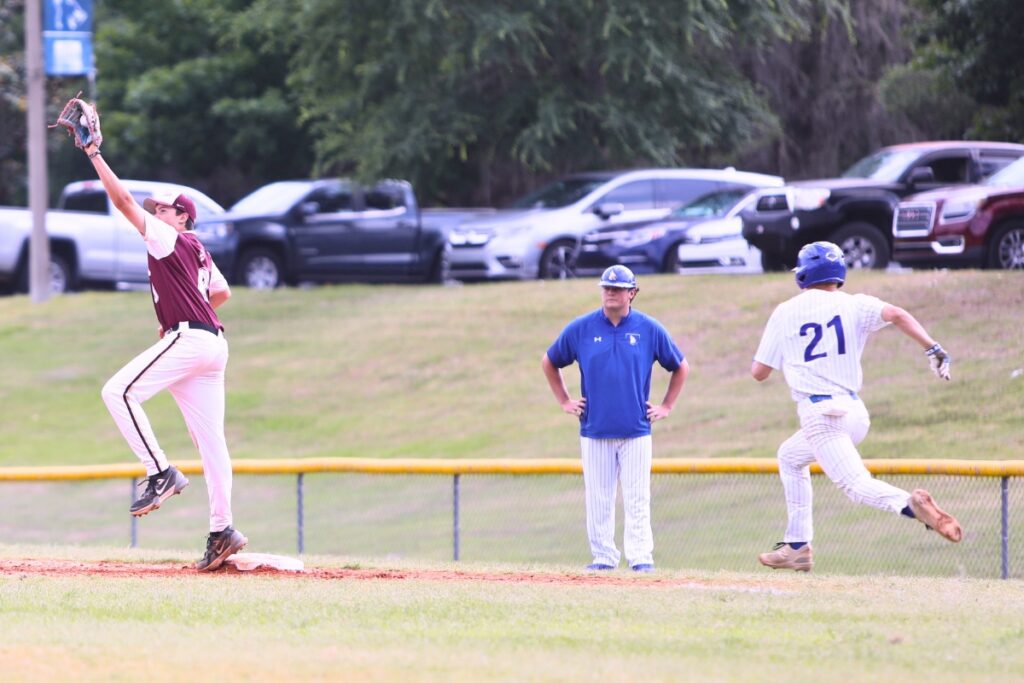 Oak Hall's Chase Wilson gets the second-inning out at first base against St. Francis Catholic's Cyrus Fariborzian (21) in game two of the 1A Regional quarterfinals. Photo by C.J. Gish