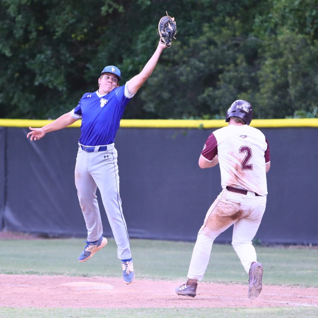 Oak Hall's Gavin Jones (2) runs safely to first base in the fifth inning after the throw to St. Francic Catholic's Liam Green pulls him off the bag in game three of the 1A Region 2 Quarterfinals.