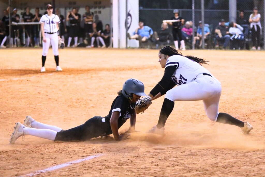 Santa Fe's Breleigh Ford (3) slides safely into third base ahead of a tag by Gainesville's Braylin Cook (27). Photo by C.J. Gish