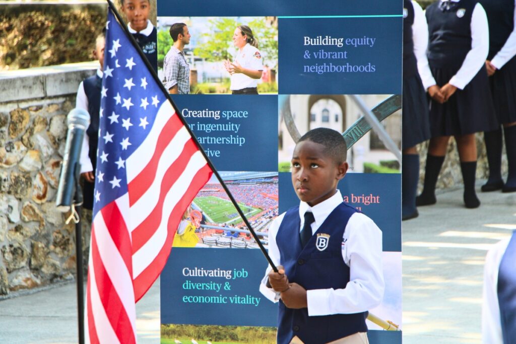 A Saint Barbara Leadership Institute student carries the American flag. Photo by Lillian Hamman