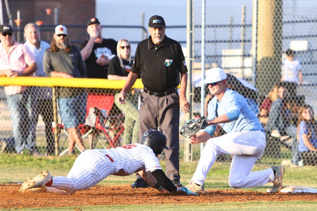 Chiefland's Trey Meeks (right) tags Trenton's Brock Petrello out at first base in the second inning in game two of the Rural Region 4 Semifinals. Photo by C.J. Gish