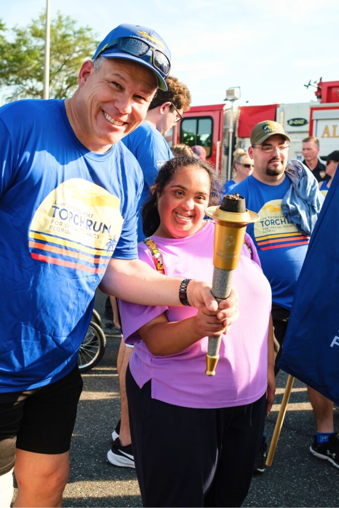 Jason Levey (left) and Gaby hold the torch the Law Enforcement Special Olympics Torch Run in Gainesville on Wednesday. Photo by Chris Watkins