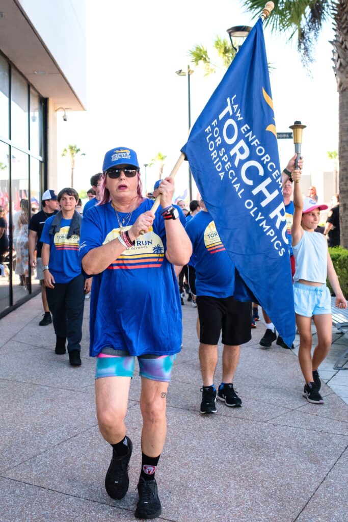 Jennifer Tozzo carries a flag during the Law Enforcement Special Olympics Torch Run at Celebration Point in Gainesville. Photo by Chris Watkins