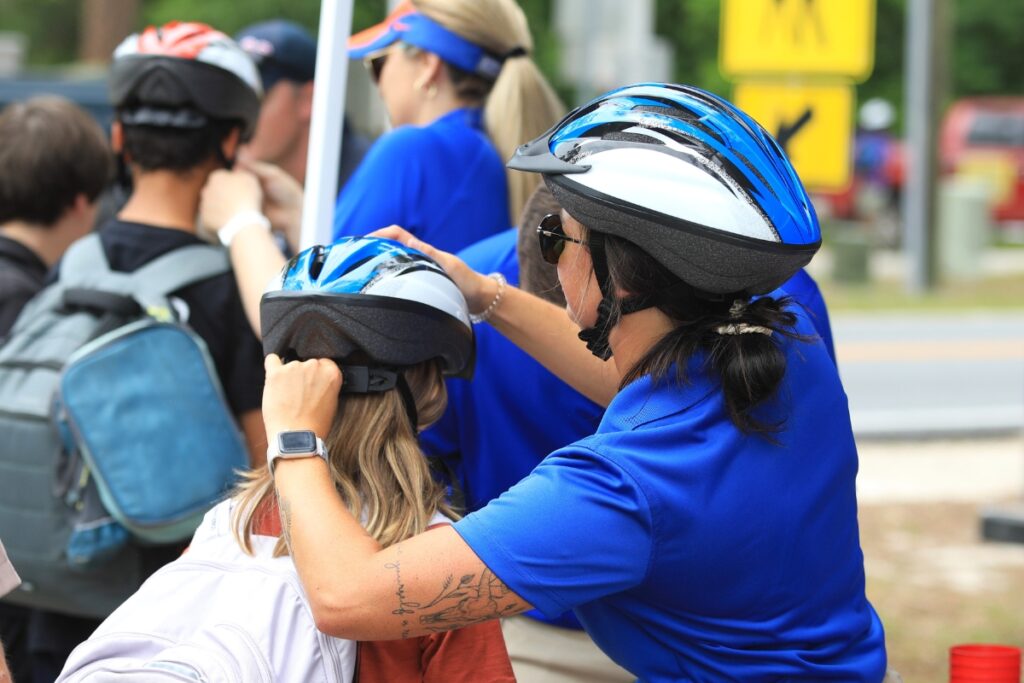 Jordyn Zyngier, coordinator for Safe Kids North Central Florida, adjusts a helmet for a student.