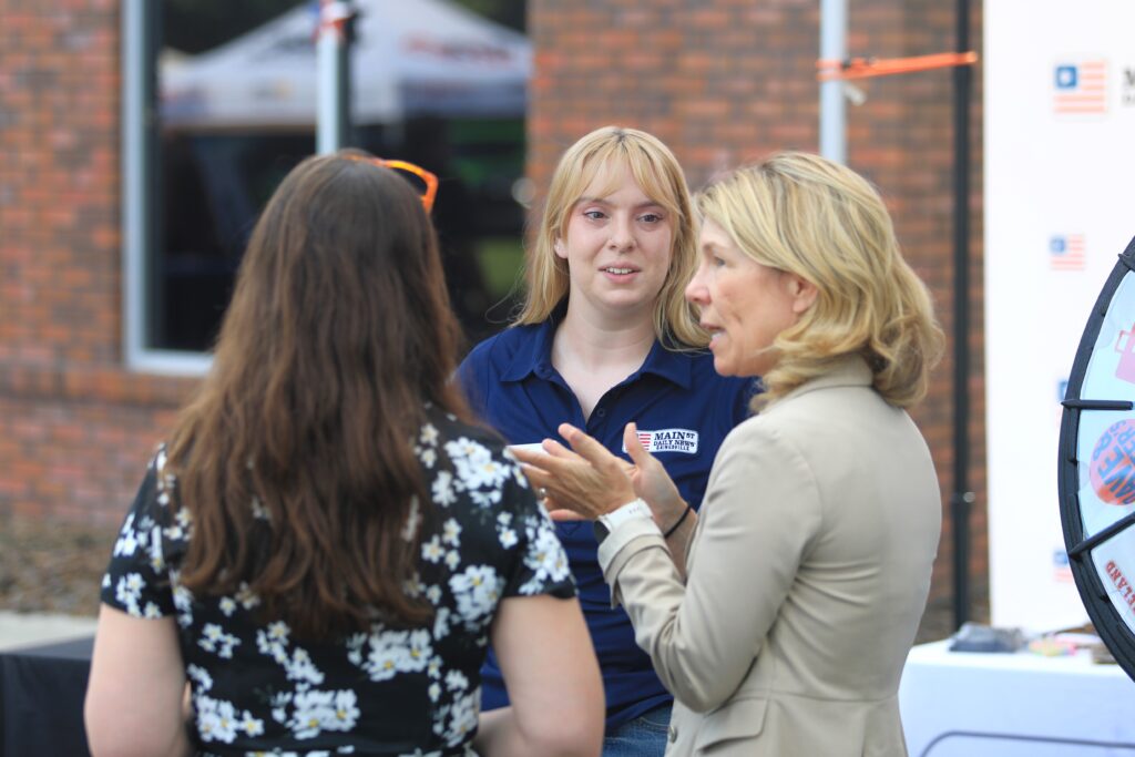 Natalie Mitchell and Janalyn Peppel greet arriving guests and let them spin to win prizes. Photo by Seth Johnson