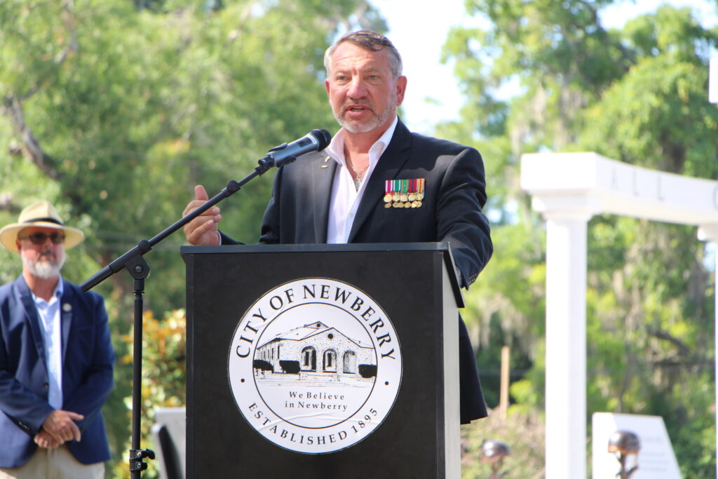 Newberry City Commissioner and retired Marine Master Sergeant Mark Clark speaks during dedication of Veterans Memorial Park.