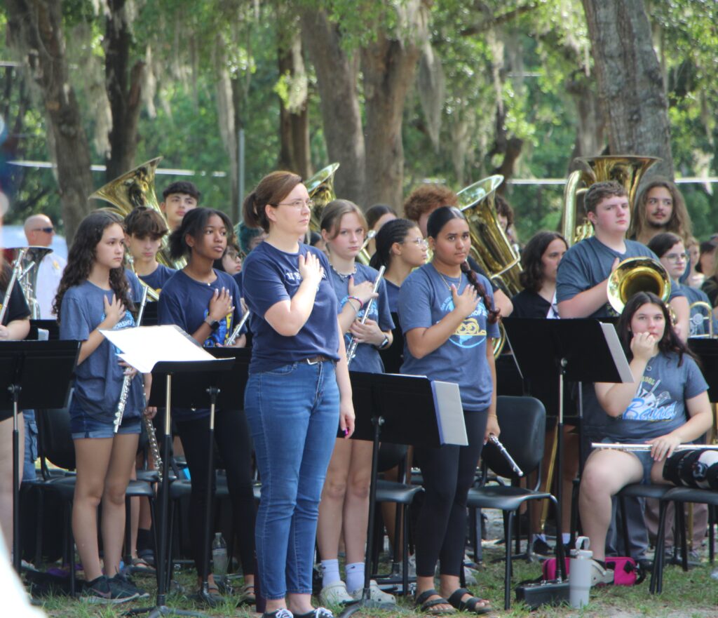 Oak View Middle School Symphonic Band stands during the Pledge of Allegiance. 