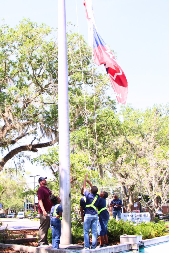 Students from Caring and Sharing Learning School raise the Juneteenth flag. Photo by Lillian Hamman