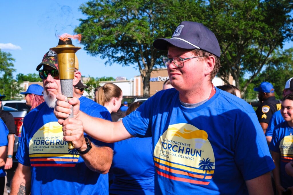 Terry Neal and Michael hold the torch during the Law Enforcement Special Olympics Torch Run in Gainesville on Wednesday. Photo by Chris Watkins
