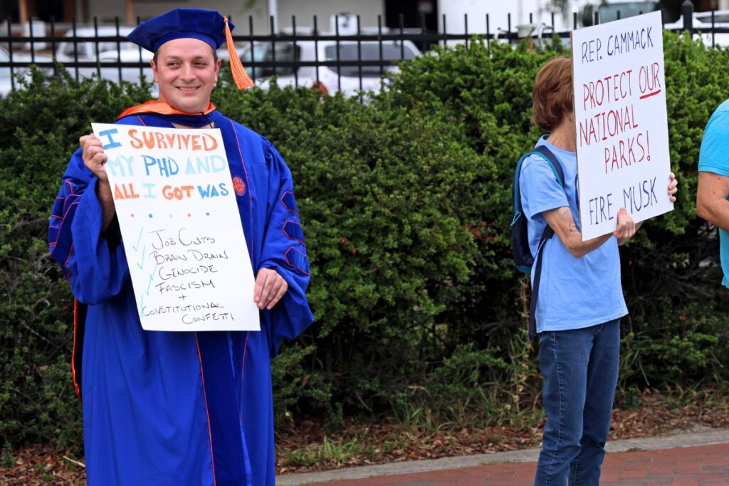 UF doctorate graduate Nathan Arndt (left) joined Thursday's anti-Trump protest.