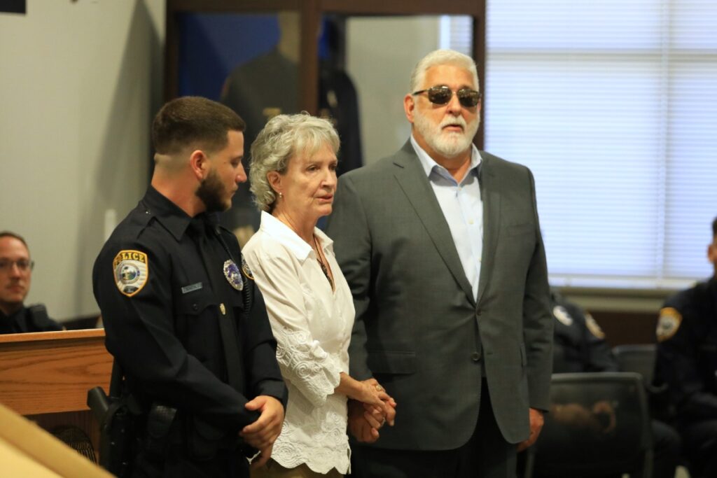 Former GPD officer and Alachua County Sheriff Sadie Darnell holds hands with Mario Taboada, brother of one of the UF murder victims, as Taboada's nephew Jordan Gonzalez joins the department.