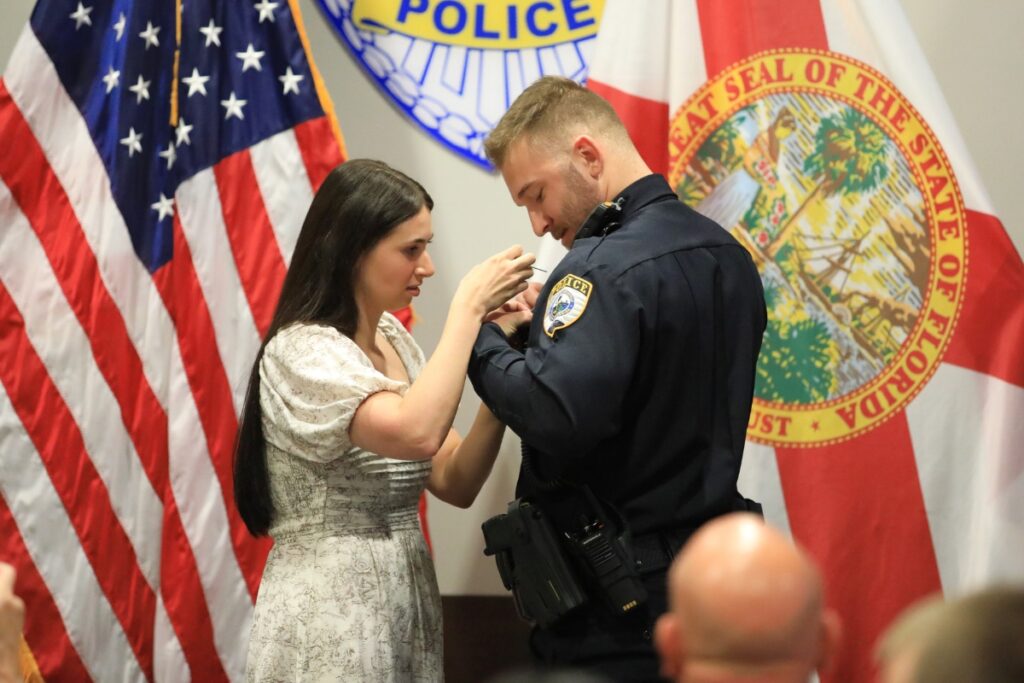 Officer Sterling Mattox has his fiancee pin his GPD badge at the department's Oath of Office Ceremony. 