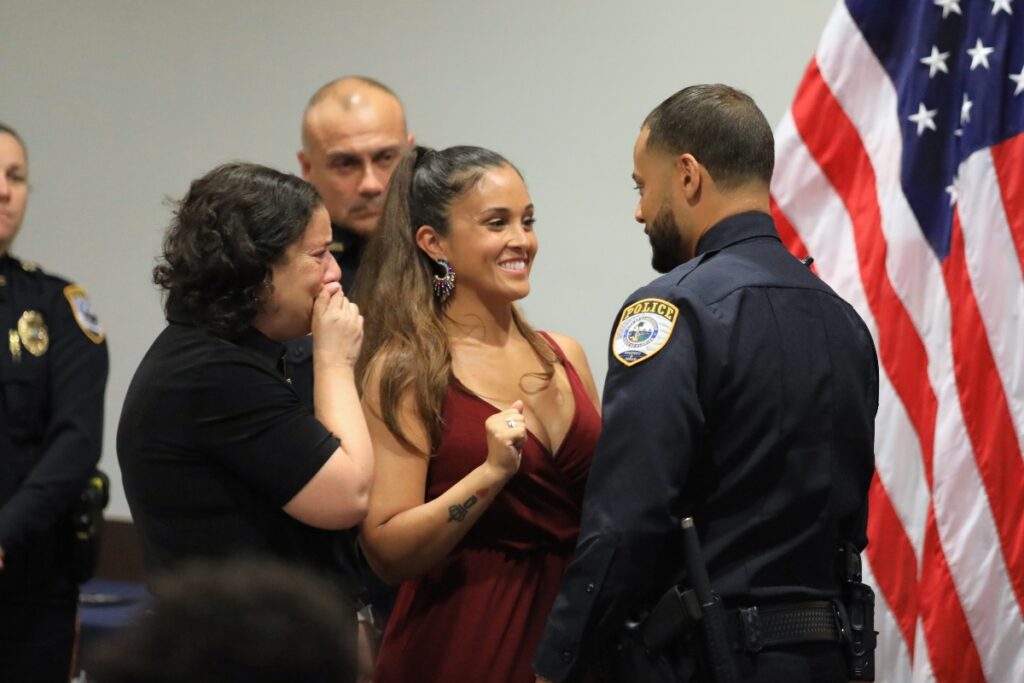 Officer Steven Centeno gets his badge pinned by his wife and mother. 