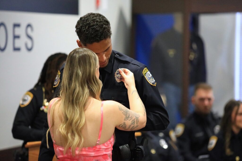 Officer Tiye Utley has his badge pinned by his girlfriend. 
