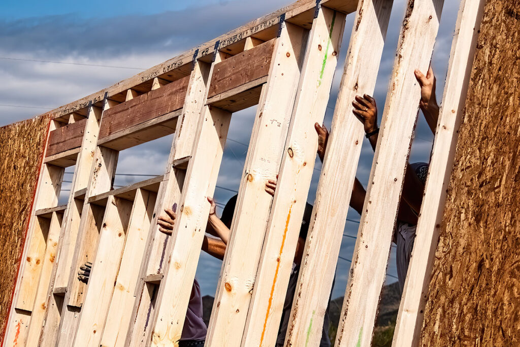 Volunteers raise a wall for a Habitat for Humanity home.