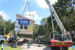 A crane lifts one section of the Habitat house off a trailer Wednesday morning.