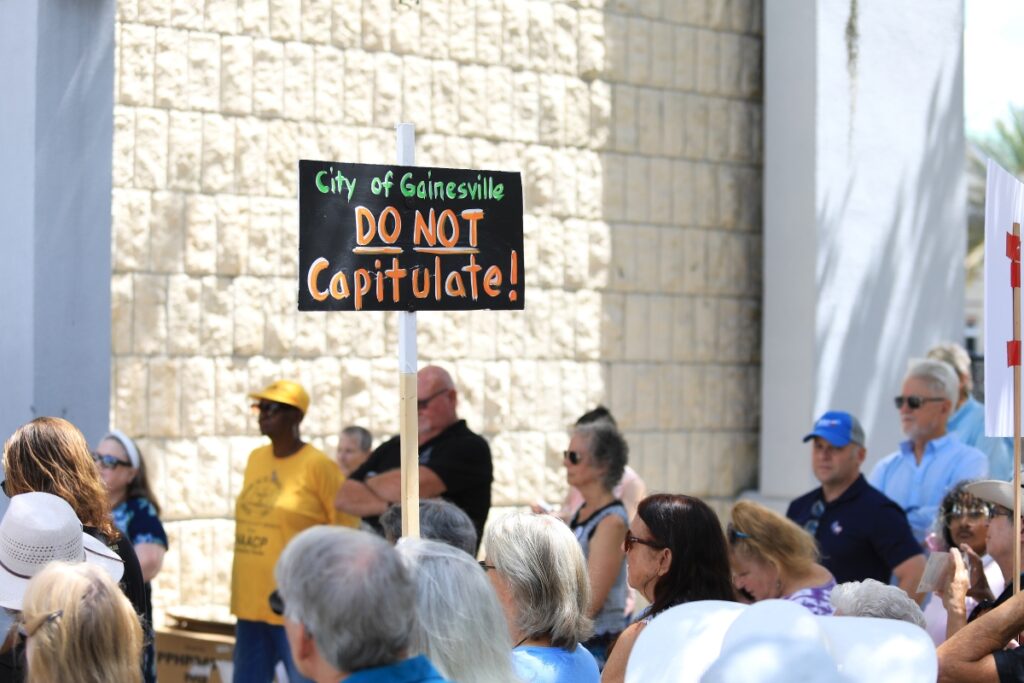 Around 50 to 60 people showed up at City Hall to protest Gov. Ron DeSantis' audit into Gainesville. 
