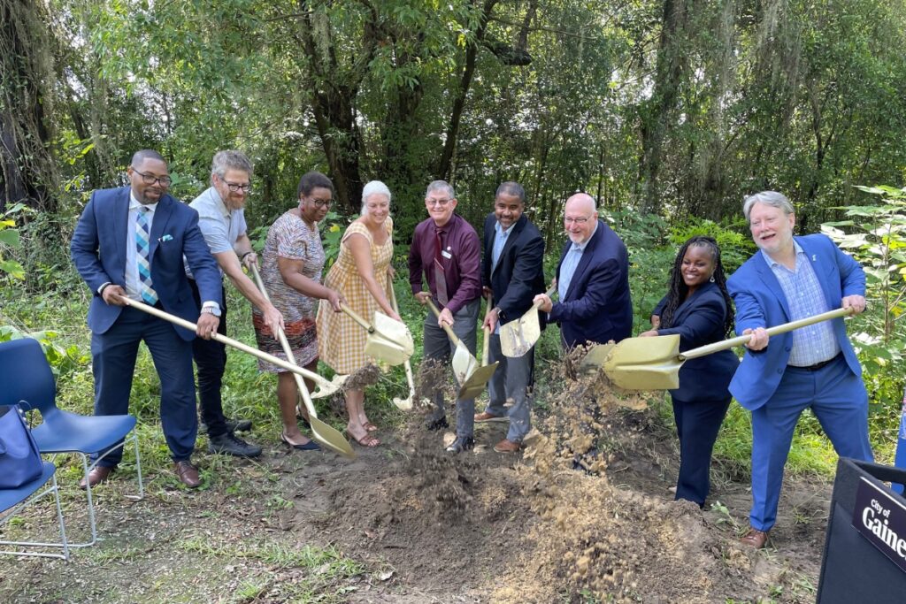 City, county and trust officials break ground on a vacant lot in southeast Gainesville. 