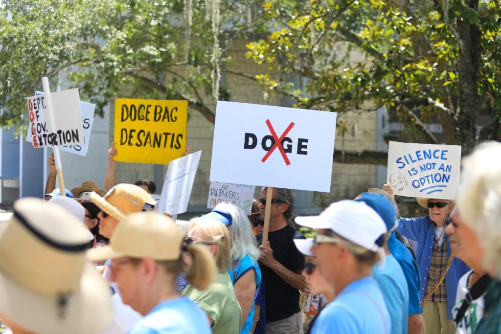Signs at a rally to oppose the Florida's slate of audits into local governments.