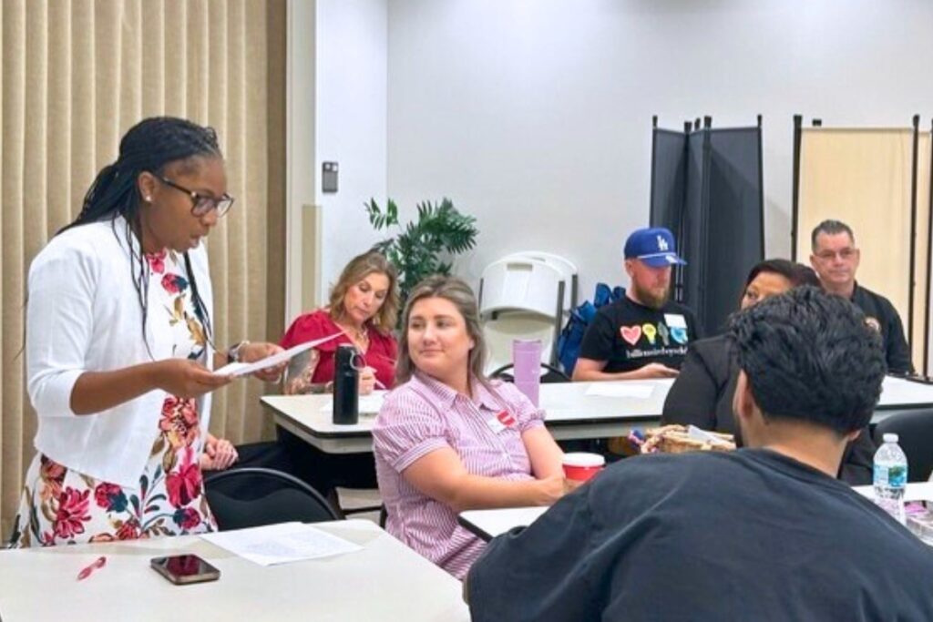A group of people attending the Safety Net Collaborative meeting take part in an exercise to try and resolve a community problem. Photo by Ronnie Lovler