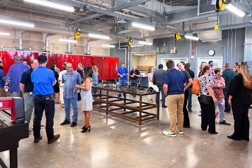 Attendees at Tuesday's ribbon-cutting ceremony socialize in the welding classroom. Photo by Nick Anschultz