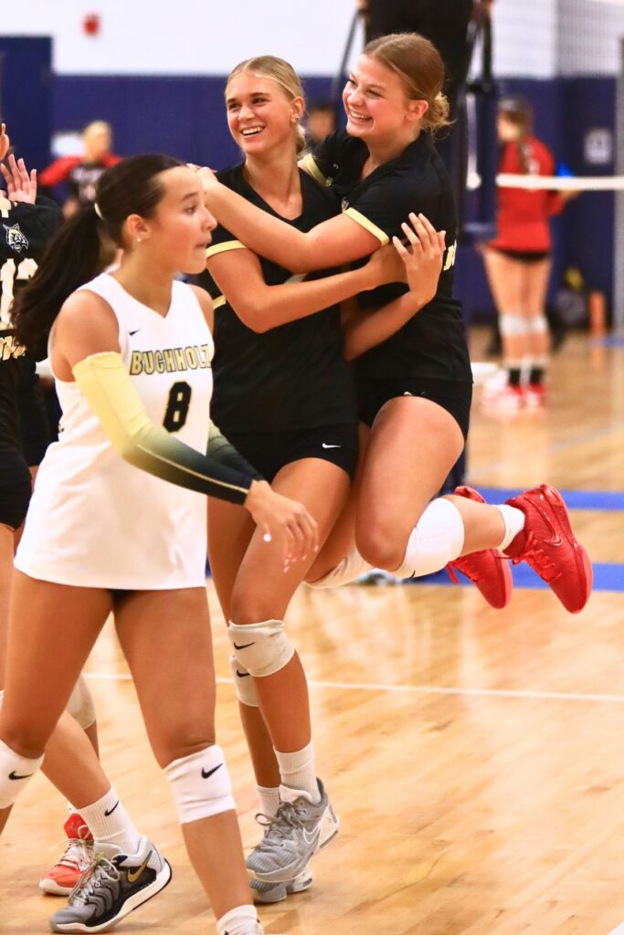 Buchholz's Addie Sixbey (center) and Julia Almond (right) celebrate after a point against Santa Fe on Thursday. Photo by C.J. Gish
