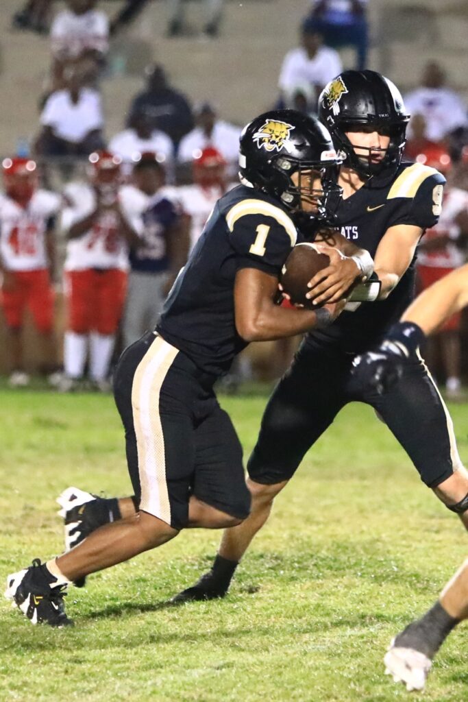 Buchholz's Andrew Whittemore (9) hands off to Chris Johnson (1) for a fourth-quarter run against Vanguard (Ocala). Photo by C.J. Gish