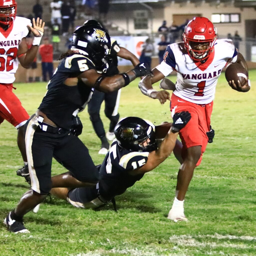 Buchholz's Caleb Young (5) and Evan Walker (15) bring down the Vanguard quarterback. Photo by C.J. Gish