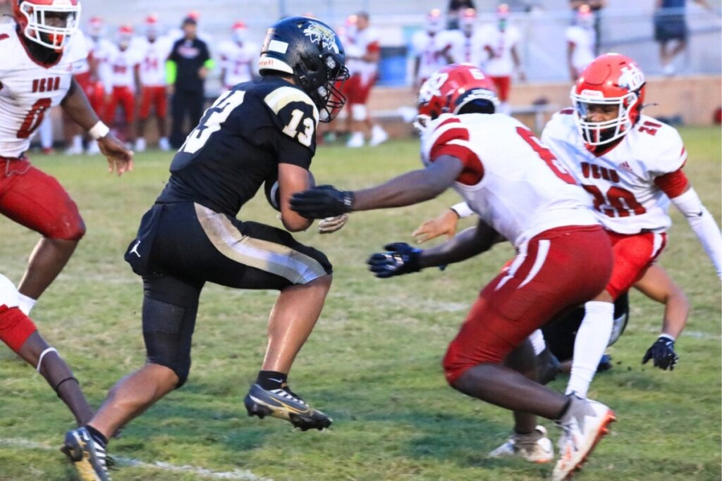 Buchholz's Justin Williams tries to weave through Vero Beach defenders. Photo by Seth Johnson