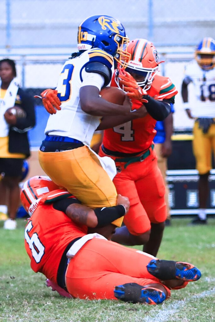 Eastside's Galen Miller (6) and Tramayne Montague (4) converge on the quarterback against Rickards (Tallahassee). Photo by C.J. Gish