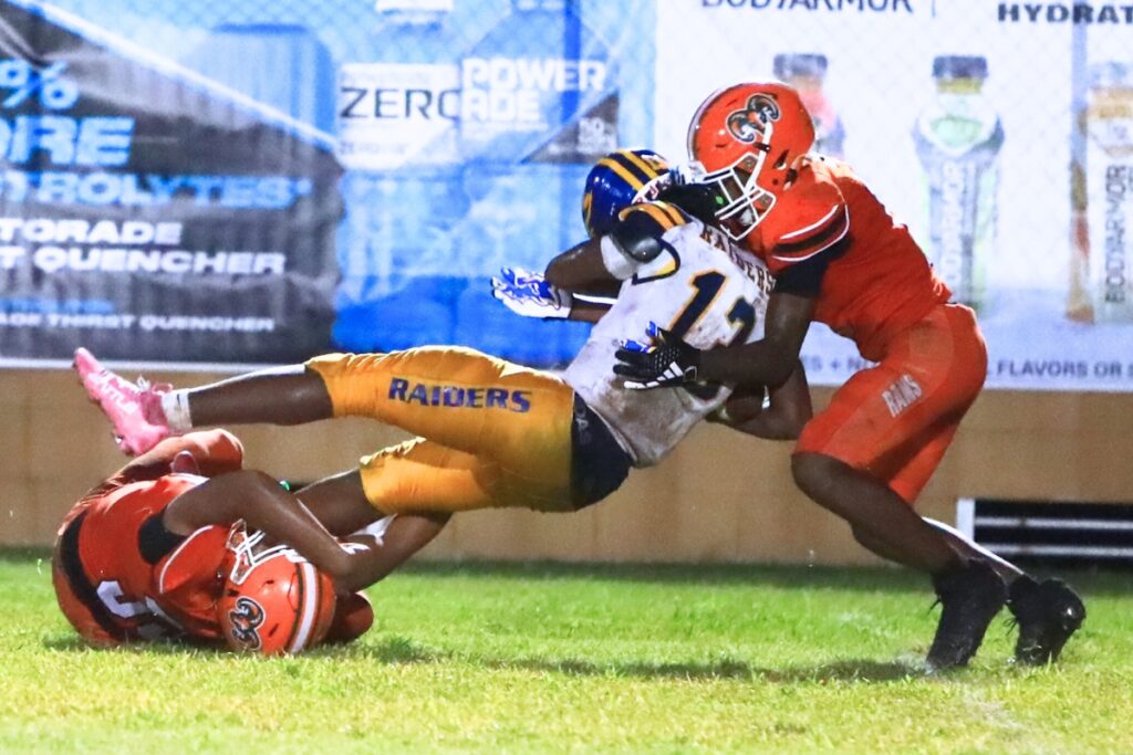 Eastside's Jaden Smith (35) and Malicah Williams (11) with a tackle against Rickards (Tallahassee). Photo by C.J. Gish