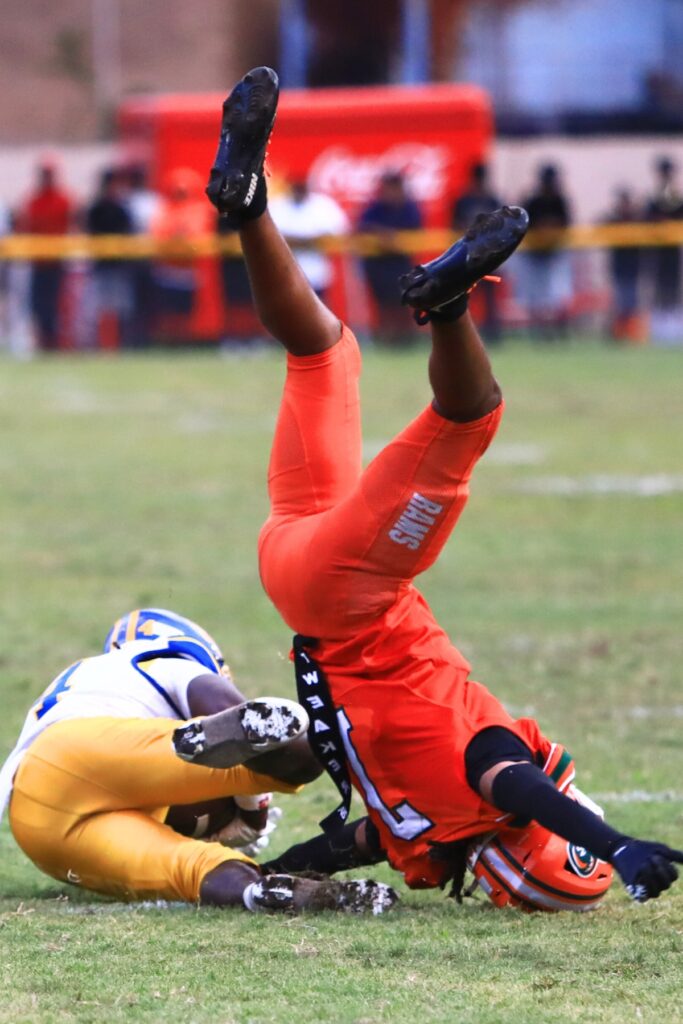 Eastside's Jayvon Comer (7) flps upside down after making a tackle against Rickards (Tallahassee). Photo by C.J. Gish