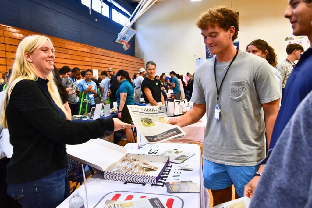 Mainstreet Daily News Membership Coordinator Natalie Mitchell (left) talks to Santa Fe College student-athletes. Photo by Janalyn Peppel