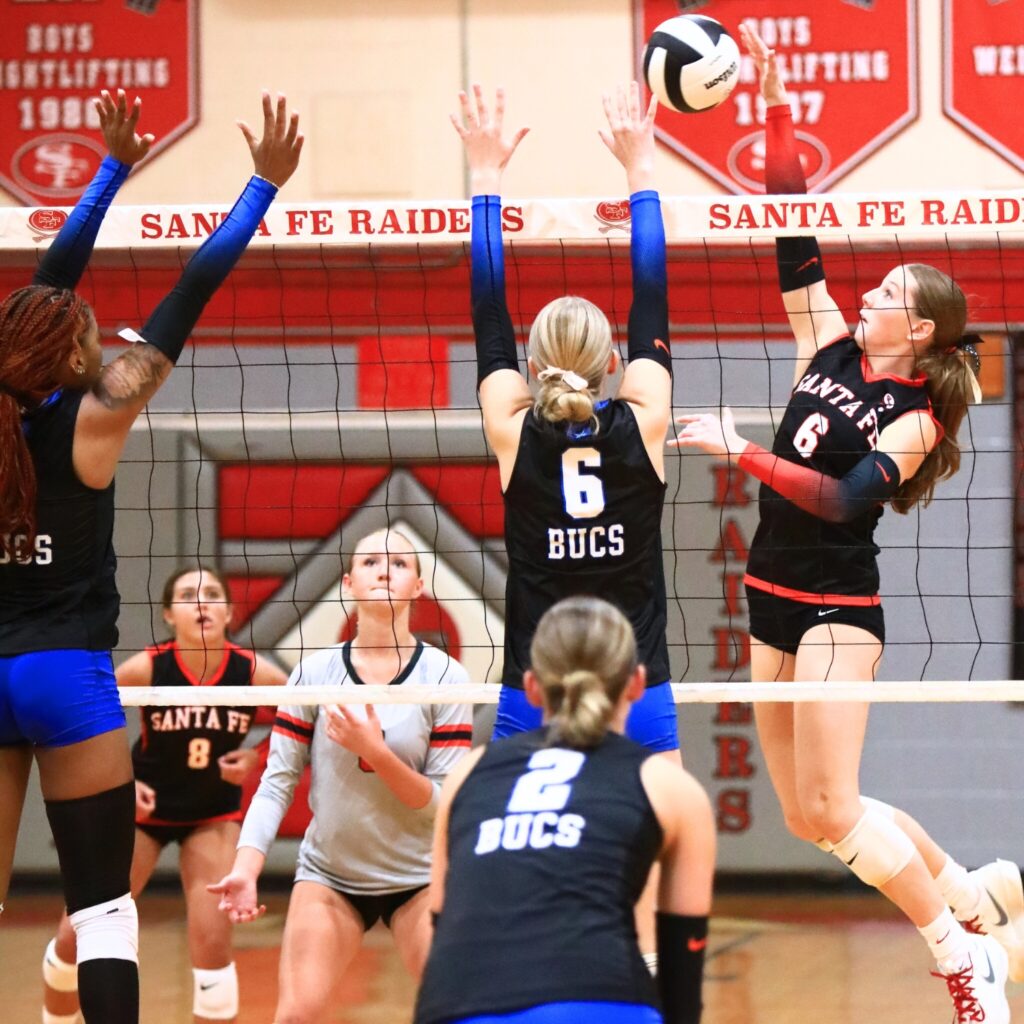 Santa Fe's Delaney Wingenbach (6) with a hit against Branford's Raelea Bradow (6) and Adriauna Combs (4). Photo by C.J. Gish