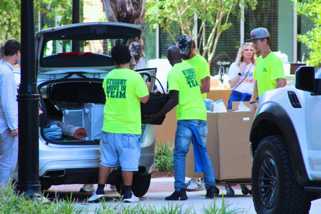 Student move-in team members help unload a vehicle at UF's Honors Village Saturday morning. Photo by Nick Anshultz